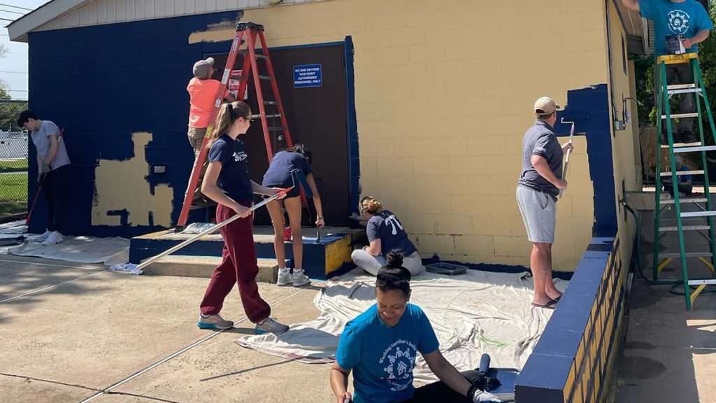 image of workers painting a building