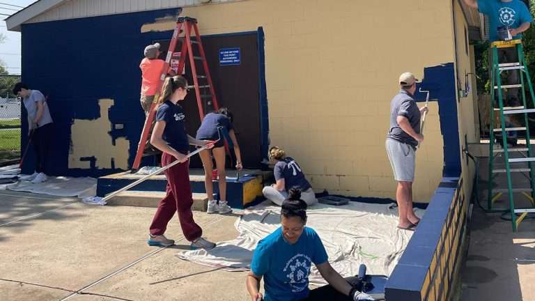 image of workers painting a building